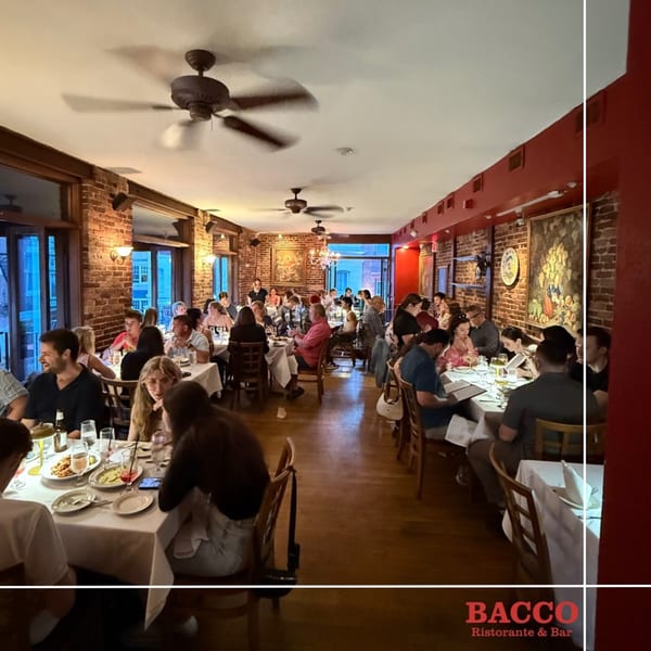 Diners enjoying meals at Bacco Ristorante & Bar, with exposed brick walls and ceiling fans.